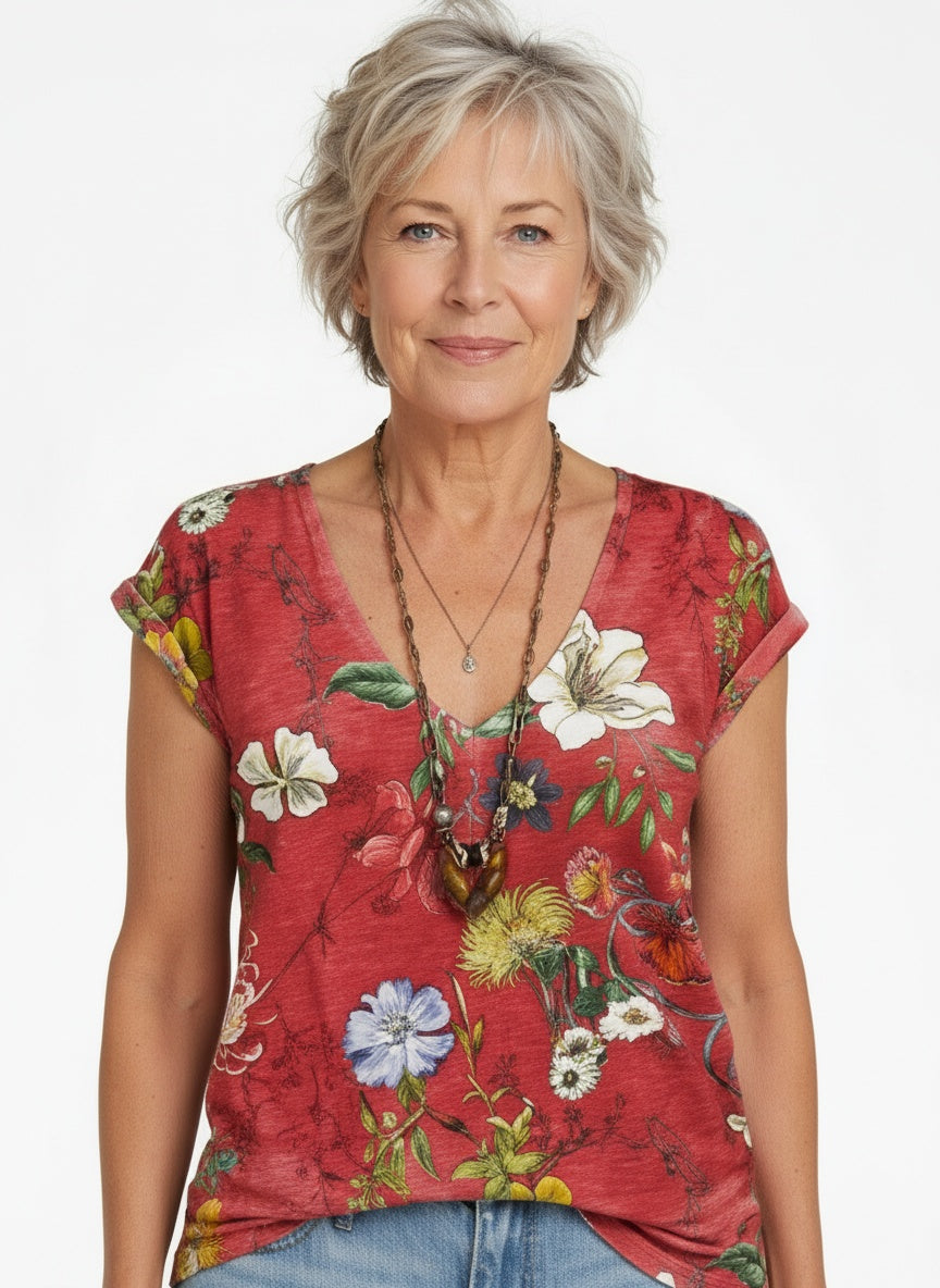 Close-up of the model wearing Vrouwelijke vloeiende T-shirt in kleurrijke stretch jersey met bloemen V-hals