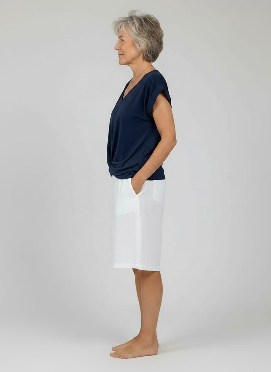 Side profile of the model wearing Elegante, vloeiende top voor dames in gemengde katoen met V-hals
