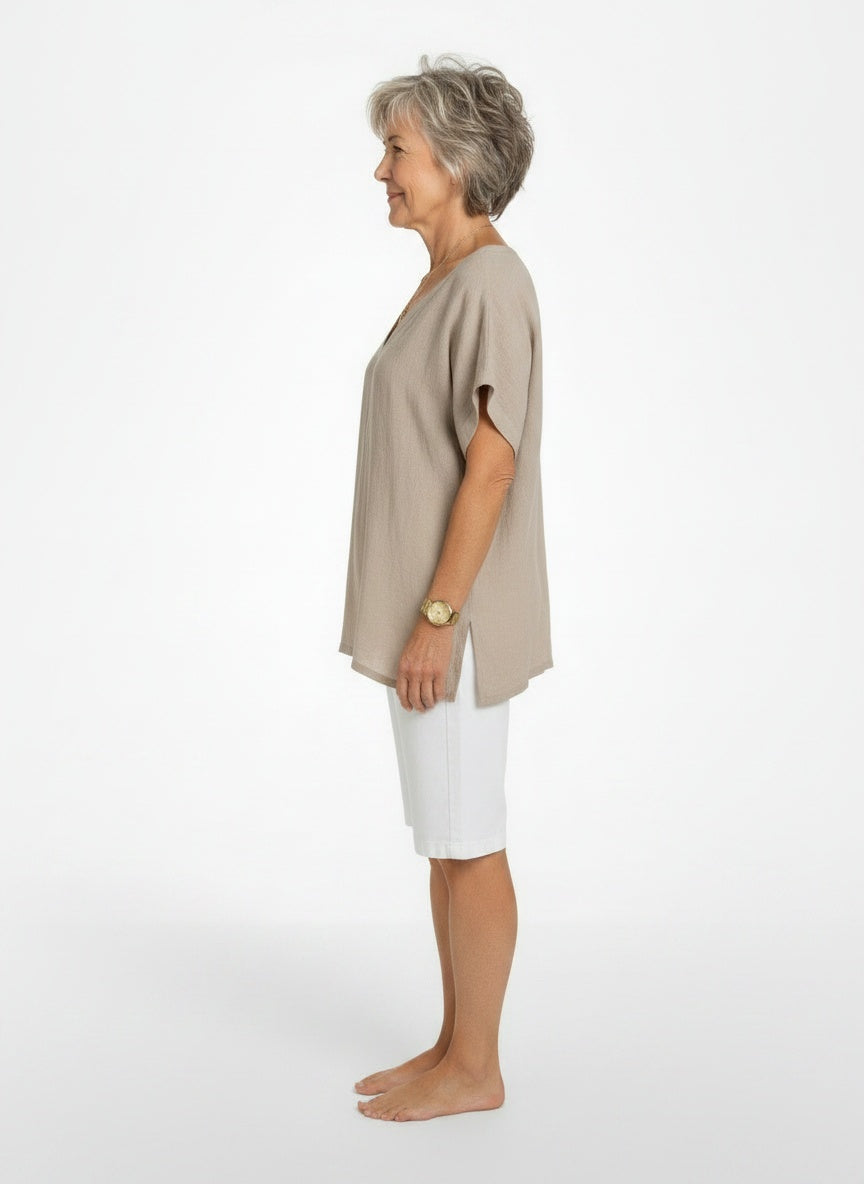 Side profile of the model wearing Losse, vloeiende dames T-shirt van zachte stof met V-hals