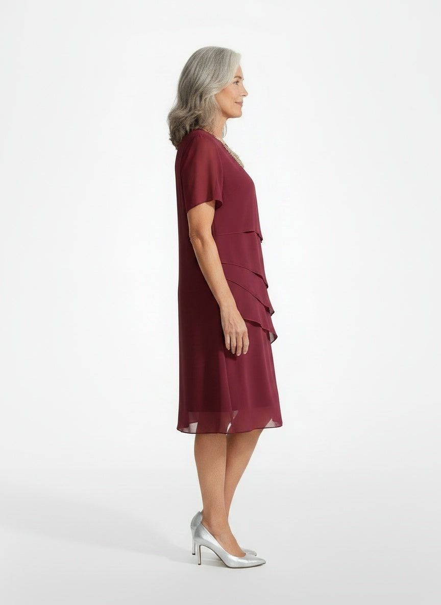 Side profile of the model wearing Apolline – Midi-jurk van chiffon met volants voor dames