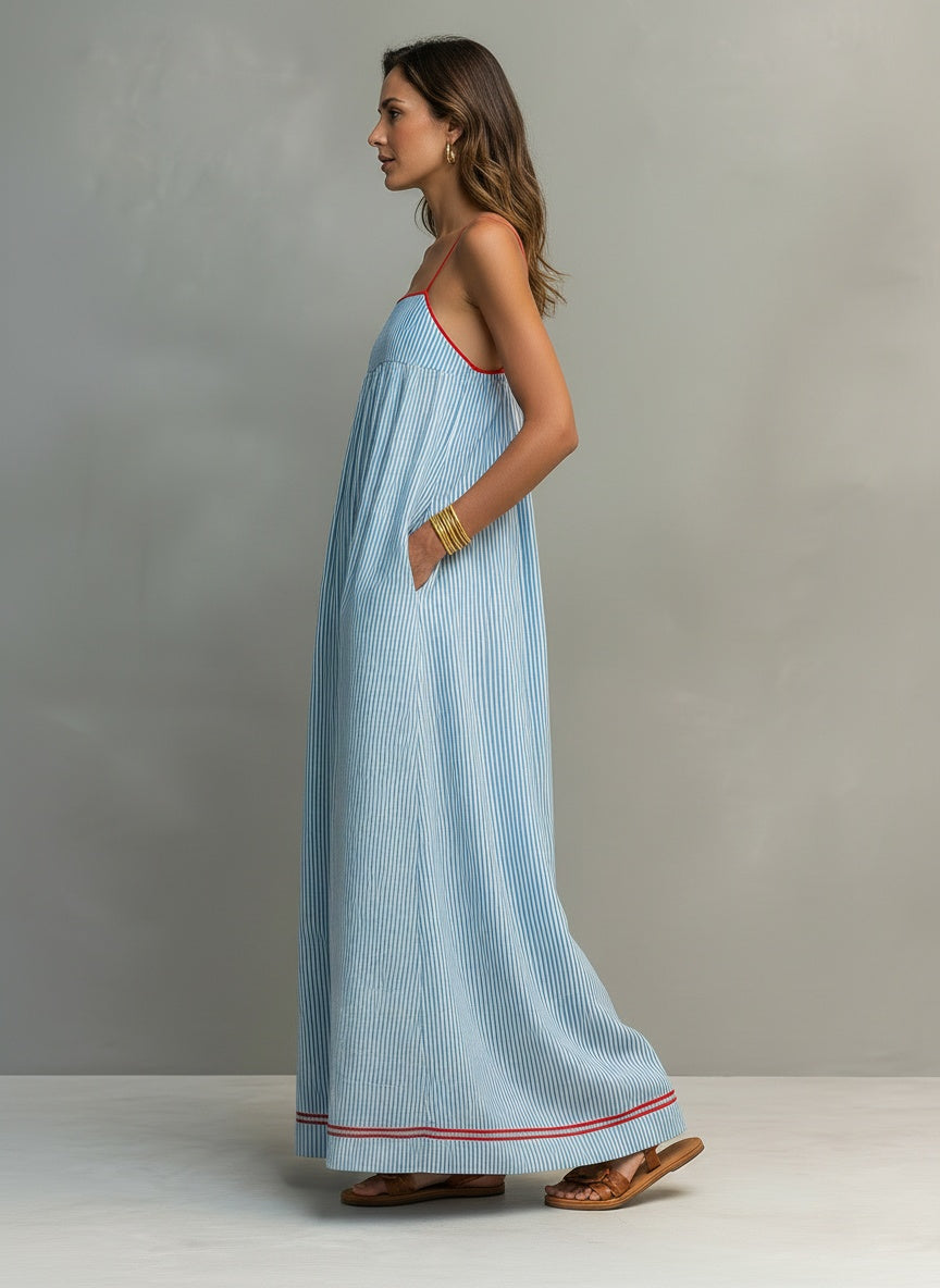 Side profile of the model wearing Maxijurk met fijne schouderbanden en bies voor dames