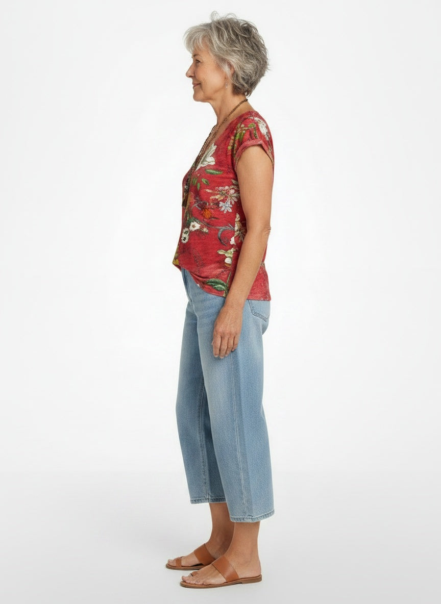 Side profile of the model wearing Vrouwelijke vloeiende T-shirt in kleurrijke stretch jersey met bloemen V-hals